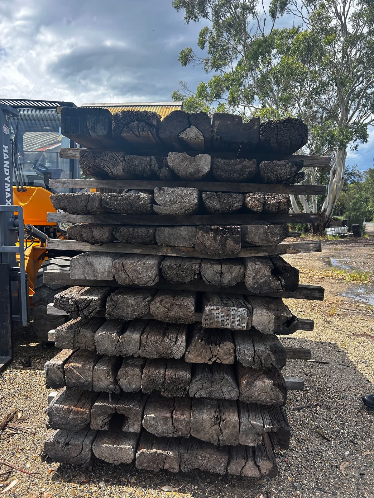 A stack of reclaimed hardwood sleepers on a truck, bound for the fit-out of Navia Bathhouse Byron Bay